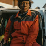 Professional cleaner in uniform sitting by service vehicle